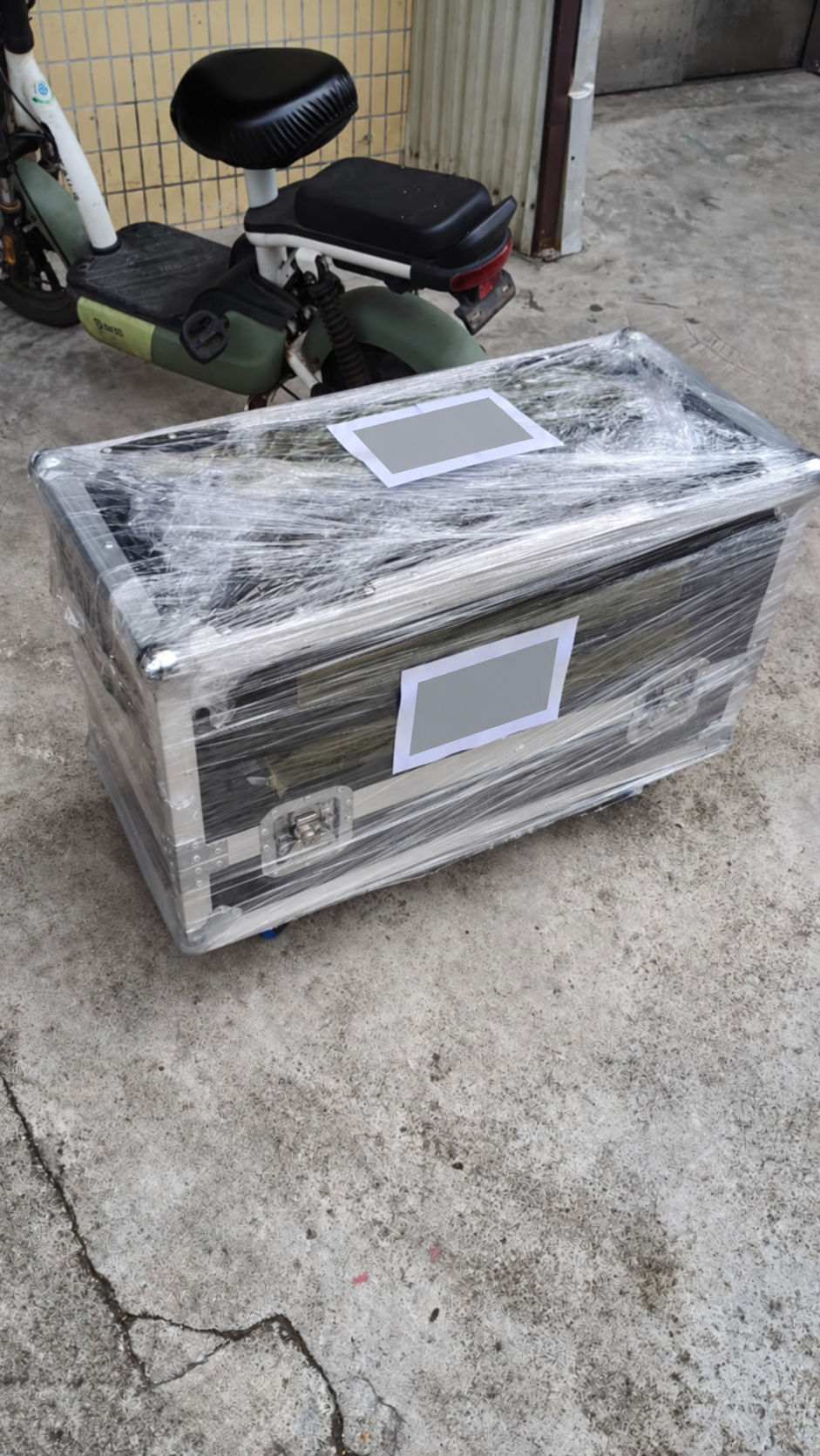 Wrapped flight case for delivery to the customer's nominated forwarder, with shipping-label details obscured